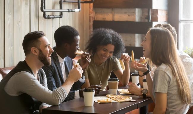 a group of people eating pizza